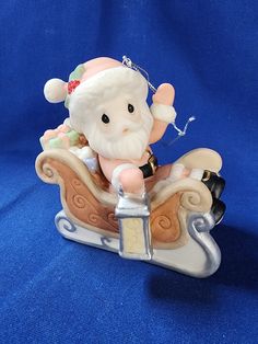 a small figurine is sitting on top of a sleigh ornament