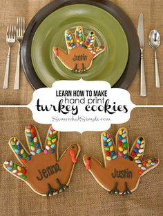 two decorated turkey cookies sitting on top of a plate next to silverware and forks