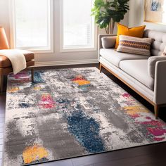 a living room area with a couch, chair and rug in grey color scheme on the floor