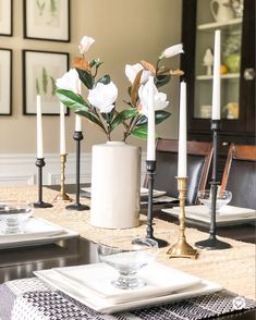 a dining room table with candles and plates