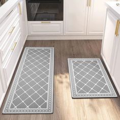 two gray rugs in the middle of a kitchen with an oven and cabinets behind them