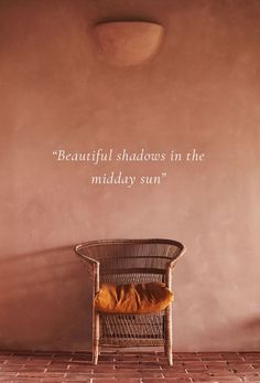 a chair sitting in front of a wall with a quote on it that reads, beautiful shadows in the middle of mid day sun