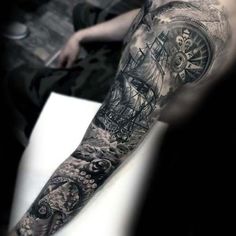 a man's arm with a clock and ship tattoo on the left side of his arm