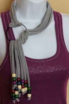 a white mannequin wearing a purple tank top and multicolored beaded necklace