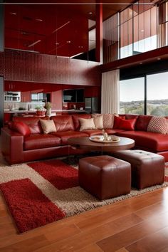 a living room filled with lots of red couches and furniture next to a large window