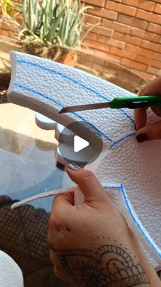 a person cutting paper with scissors on top of a table