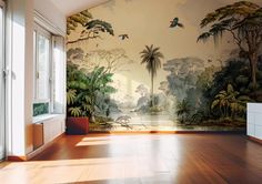 an empty room with a mural on the wall and wooden flooring in front of it