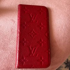 a red case sitting on top of a pink surface