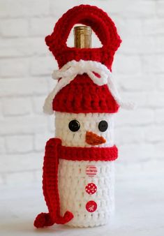 a crocheted snowman wine bottle cozy pattern is shown with the words free on it