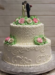 a white wedding cake with pink and green flowers