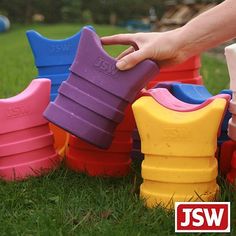 a person is picking up plastic shoes from the grass in front of some children's toys