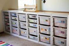 several bins are stacked on top of each other in front of a wall mounted clock