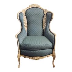 an ornate chair with blue upholstered fabric and gold trimming on the back