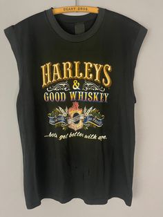 "Vintage Harley Davidson motorcycle tank top/T-shirt, Harley's and Whiskey rare graphic New York, muscle tee, soft worn in 80s biker shirt TAG SIZE: n/a MATERIAL: n/a MEASUREMENTS LAYING FLAT in INCHES: SHOULDER TO SHOULDER: 18 1/2\" ARMPIT TO ARMPIT: 20 1/2\" LENGTH TO WAISTLINE: 25\" # 402 ALL T-SHIRTS IN MY SHOP ARE TRUE GENUINE VINTAGE, NOT REPRINTS! I AM HAPPY TO COMBINE SHIPPING ON MULTIPLE ITEMS, IF YOU HAVE ANY QUESTIONS OR REQUESTS PLEASE FEEL FREE TO REACH OUT AND I WILL ACCOMMODATE YO Vintage Sleeveless T-shirt With Graphic Print, Summer Grunge Crew Neck Muscle Tee, Summer Grunge Muscle Tee With Crew Neck, Vintage Tank T-shirt For Summer, Tank T-shirt With Letter Print For Streetwear, Retro Tank Tops With Letter Print, Distressed Crew Neck Muscle Tee For Streetwear, Grunge Crew Neck Tank Top With Letter Print, Grunge Cotton Tops For Biker Events