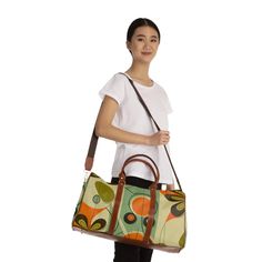 Jet set in psychedelic style with this retro 1960s inspired daisy duffel bag. Featuring a bold floral print in mod colors, this groovy weekender carry-on pops with flower power vibes. Expertly crafted from high grade materials with leather accents, this 20" × 12'' × 9" overnight bag is ideal for quick trips and weekend getaways. The vibrant daisy pattern and geometric details give this hip bag far out old school flair. Pack in peace and travel back to the age of free love with this funky floral Retro Shoulder Bag With Zipper For Shopping, Retro Shoulder Bag With Zipper Closure For Shopping, Retro Green Bags With Adjustable Strap, Retro Green Satchel Shoulder Bag, Green Retro Shoulder Bag For Shopping, Retro Green Bags, Retro Green Satchel With Adjustable Strap, Retro Travel Satchel Bag, Green Retro Satchel With Adjustable Strap