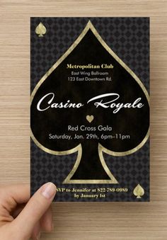 a person holding up a card with the name casino royale in gold and black on it