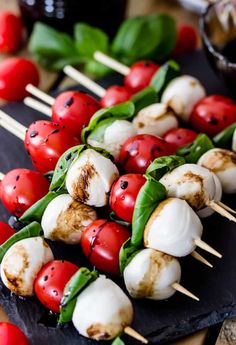 several skewers with tomatoes, mozzarella and basil on them are ready to be served