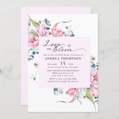 a pink and blue floral wedding card with the words love is in bloom on it