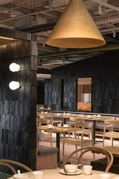 an empty restaurant with tables and chairs in the center, lights hanging from the ceiling