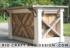 an outdoor kitchen made out of wood and white paint with sliding doors on the side