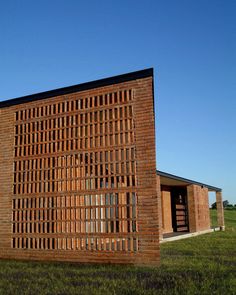 a building made out of bricks sitting in the grass