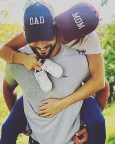 a man and woman hug each other while wearing dad's hats on their heads