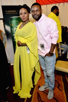 a man and woman standing next to each other in front of a poster at an event