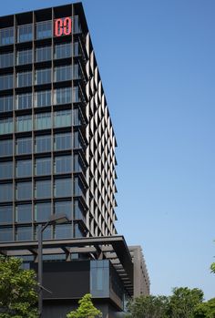 a tall black building with the number 60 on it's side in front of trees