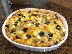 a casserole dish with olives, peppers and onions in it on a counter