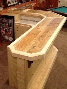 a pool table made out of pallet wood in a room with other items on the floor