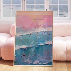 a painting is hanging on the wall in front of a couch with a pink and blue background