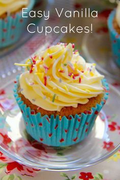 cupcakes with white frosting and sprinkles are on a plate