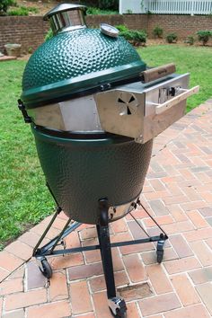 a big green egg grill sitting on top of a brick patio