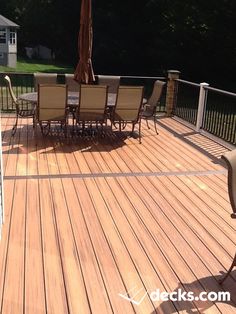 a wooden deck with chairs and an umbrella