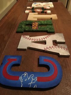 baseball themed wooden letters are lined up on a long table in front of an oven