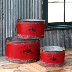 three red buckets sitting on top of a wooden floor