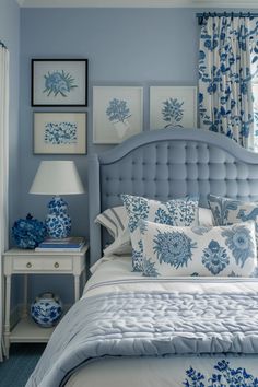 a blue and white bedroom with pictures on the wall above the bed, along with two nightstands