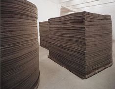 several stacks of brown paper sitting on top of each other in front of a white wall