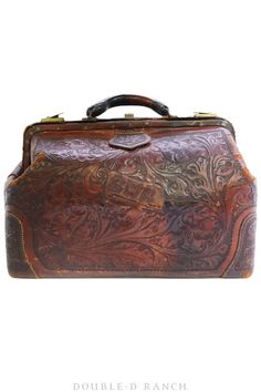 an old brown leather suitcase with intricate carvings