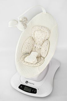 a white baby's cradle sitting on top of a scale with its cover pulled down