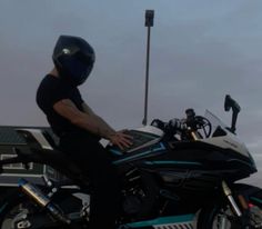 a man sitting on top of a blue motorcycle