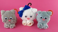 three stuffed animals sitting next to each other on a pink background