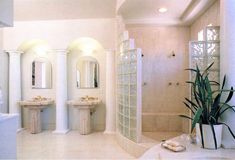 a large bathroom with two sinks and three mirrors on the wall next to each other