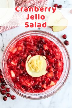 cranberry jello salad in a glass bowl with an apple slice on top