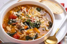 a white plate topped with a bowl of soup and two slices of bread on the side