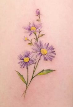 the back of a woman's stomach with purple daisies tattooed on her side