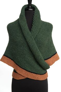 a green and brown knitted shawl on a mannequin