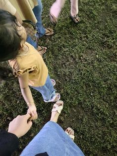 several people standing in the grass with their feet on each other's hipss