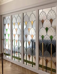 three glass doors with art deco designs on the front and back panels in different colors