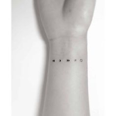 a person's arm with an arrow tattoo on the left side of their wrist